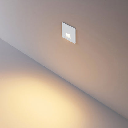 Vierkant wit kapje gemonteerd in de wand, brede lichtbundel over de trede
