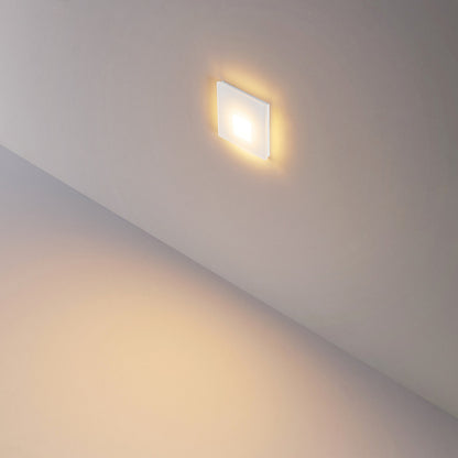 Vierkant wit glaskapje gemonteerd in de wand, diffuus licht op de trede